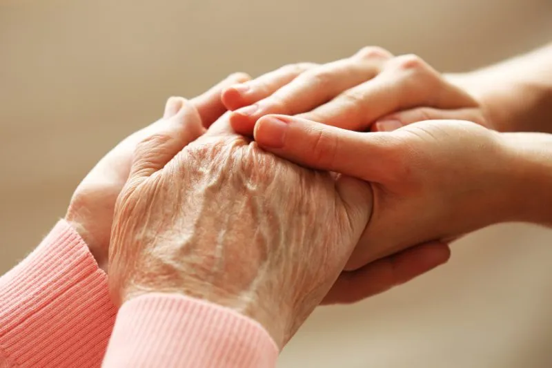 Deux mains qui se tiennent, celle d'une personne âgée et celle de son proche
